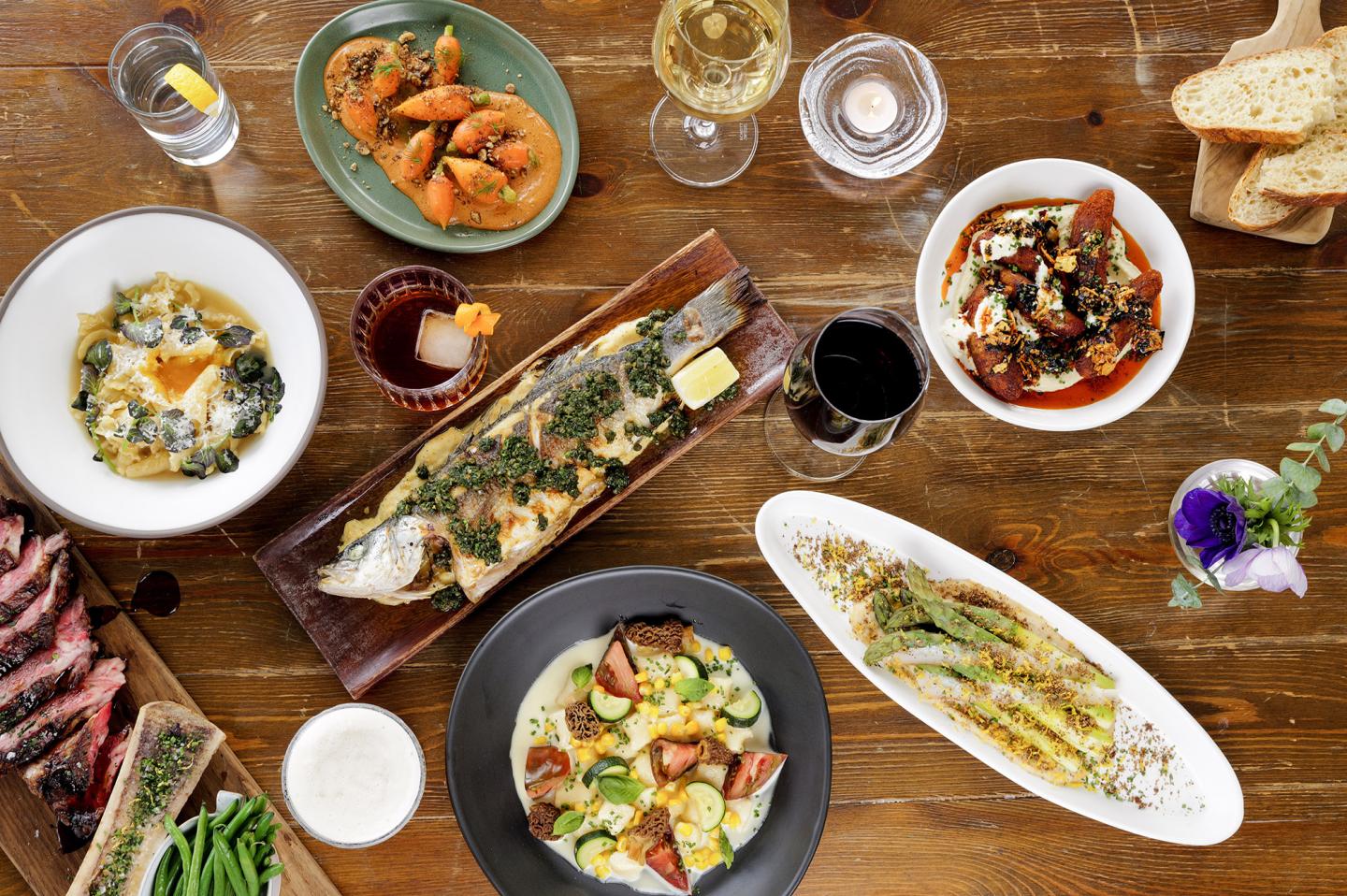 Assorted dishes and drinks on a wooden table.