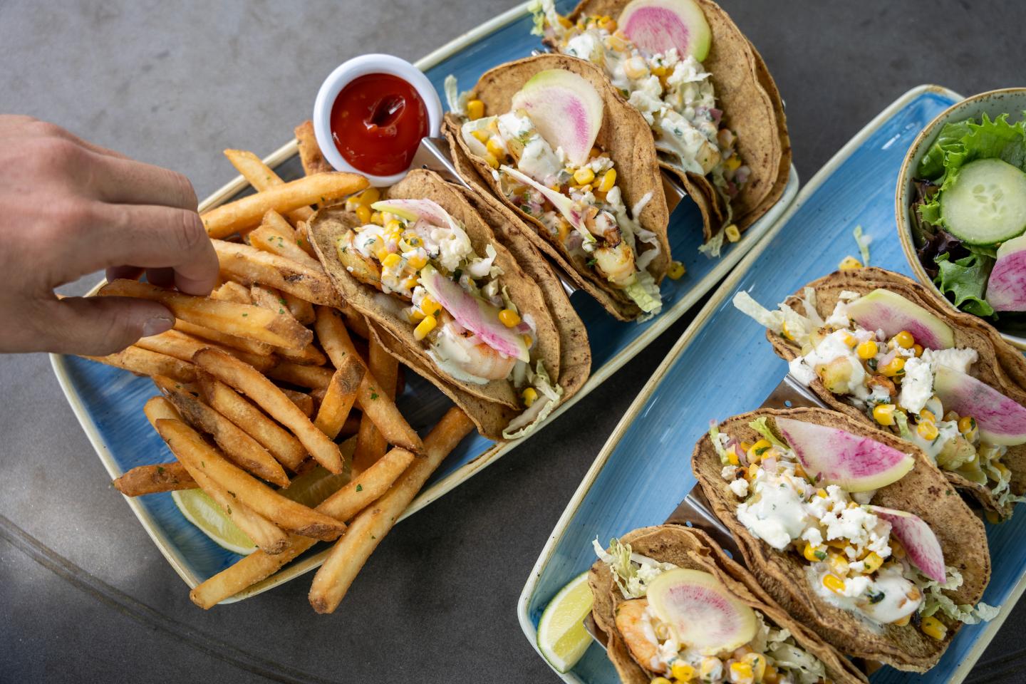 Tacos with corn and radish, served with fries and ketchup.