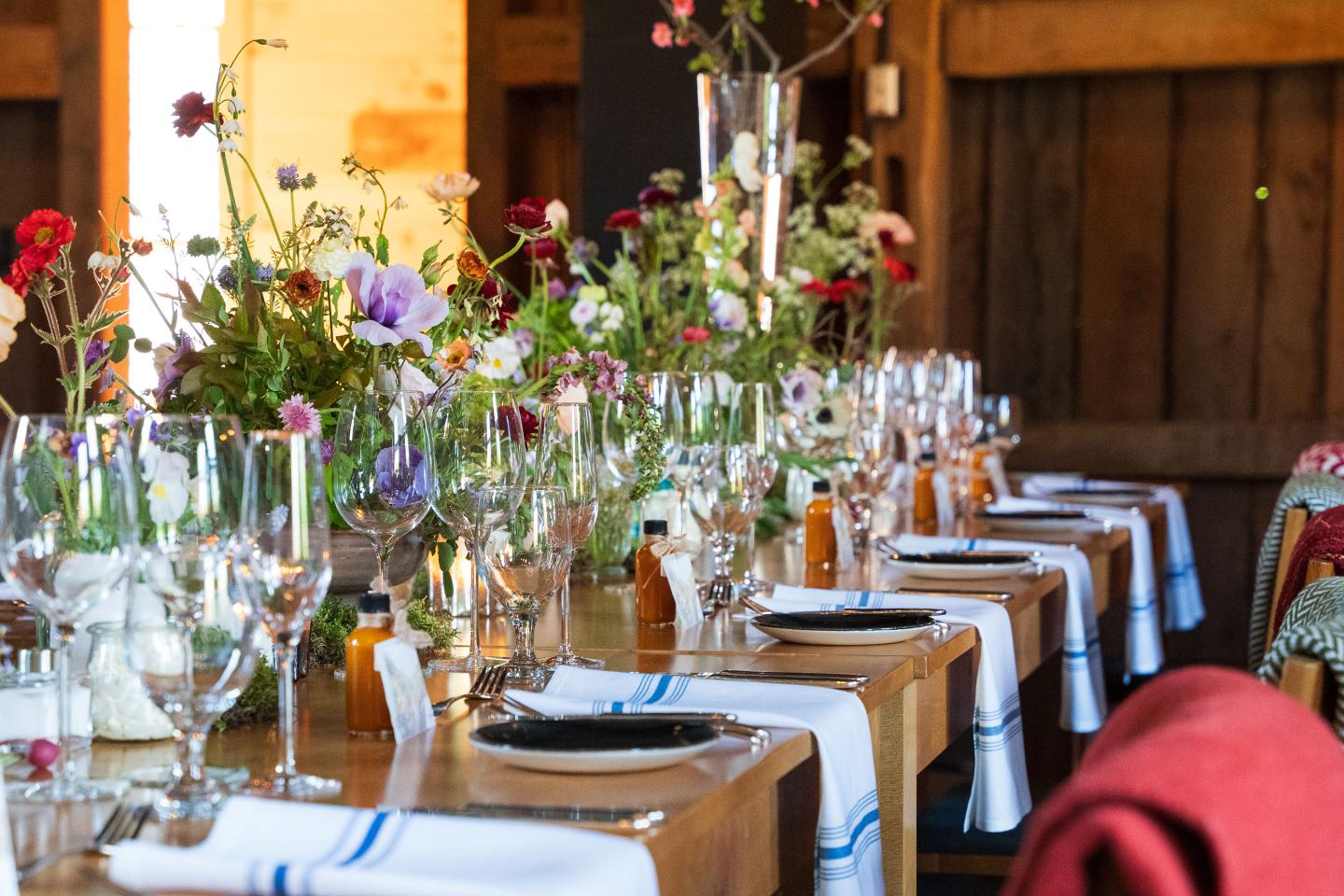 Elegant table setting with flowers and glassware in a rustic room.