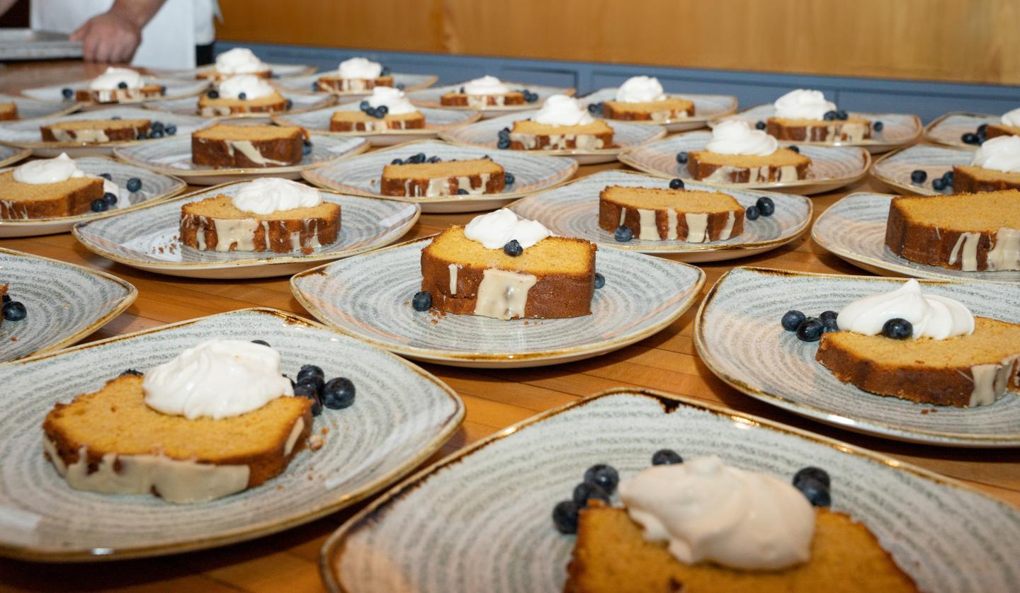 Slices of cake with cream and blueberries on plates.