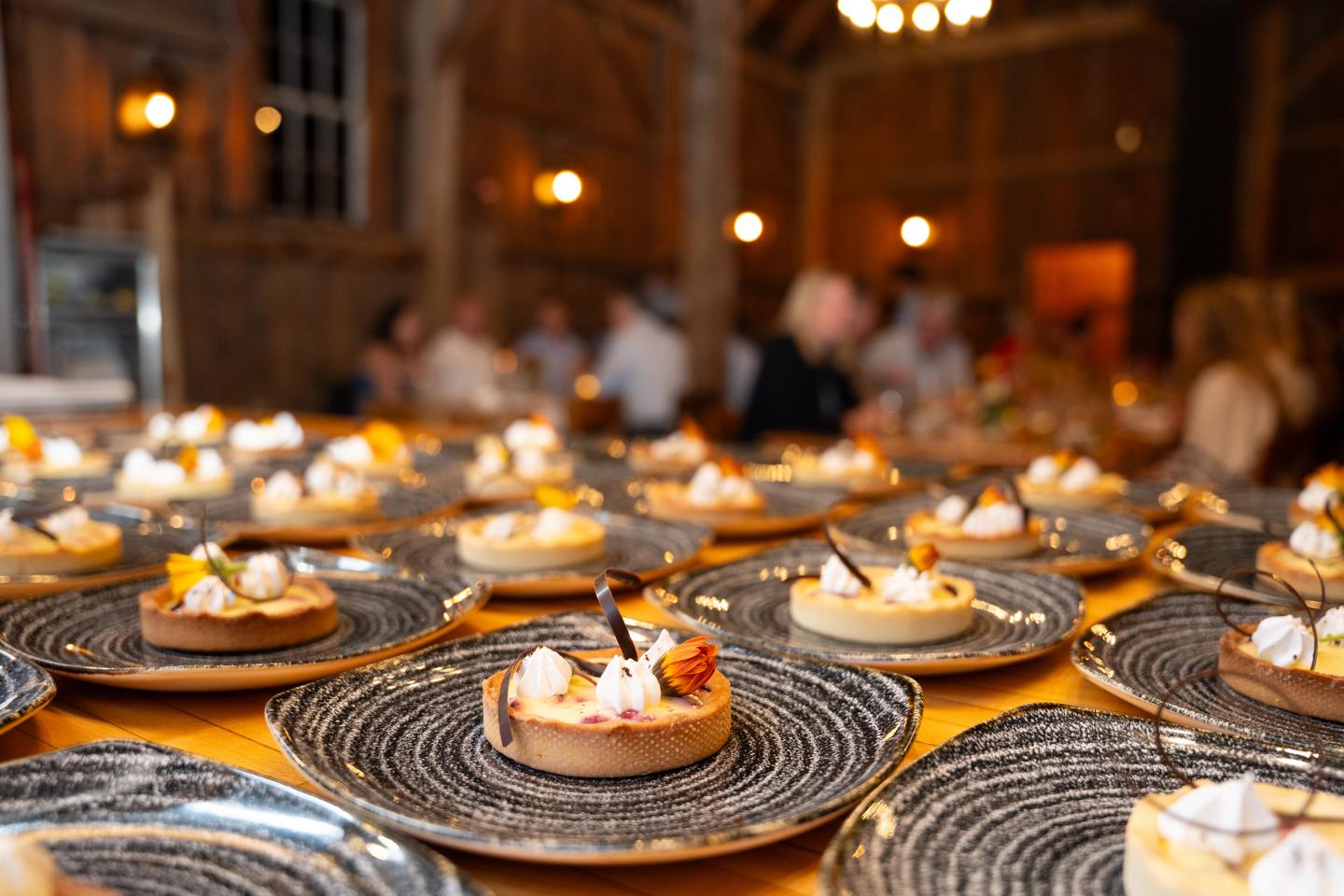 Plated desserts on a table in a warmly lit dining hall.