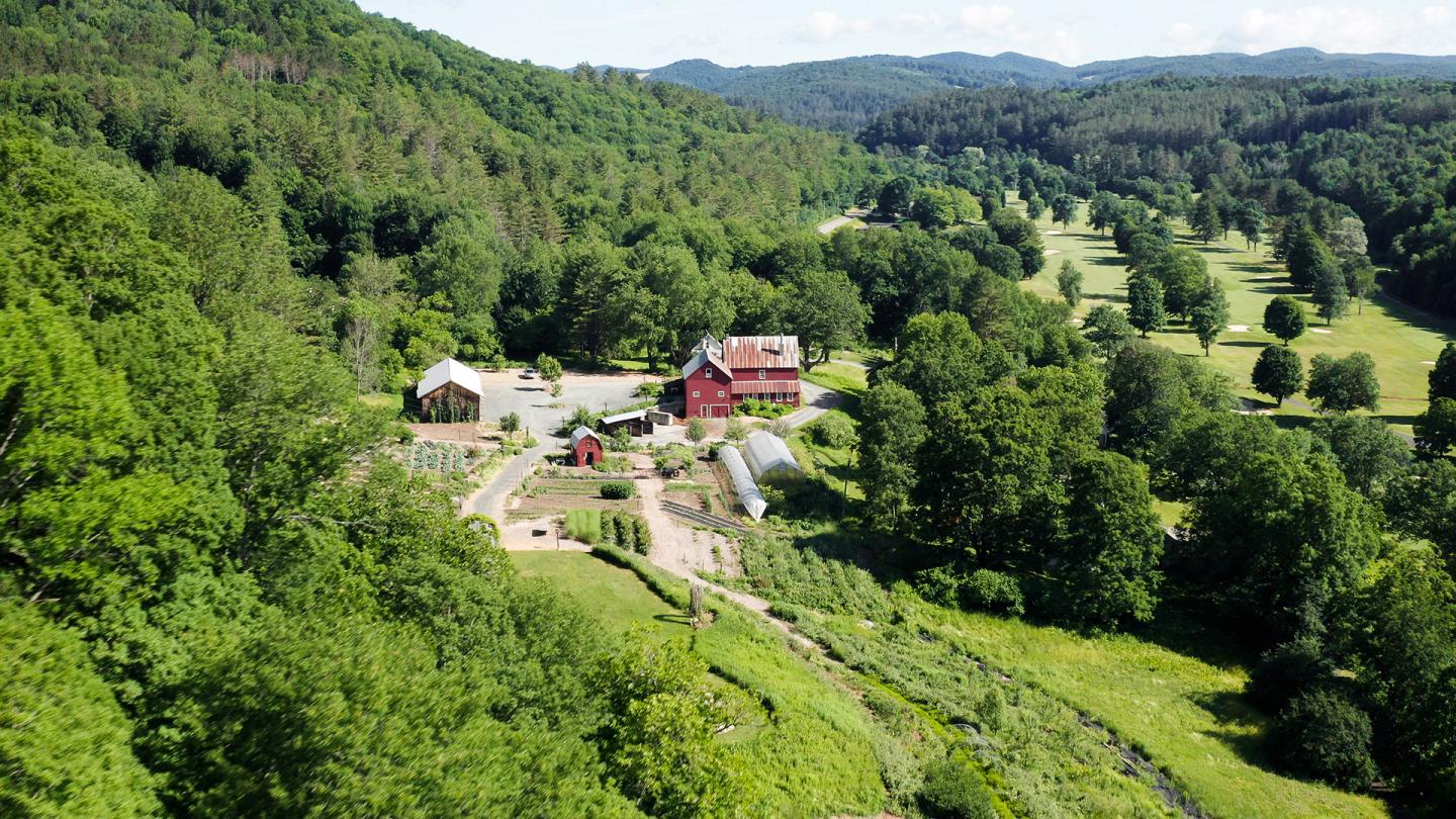 Aerial view of a farm in a lush green valley.