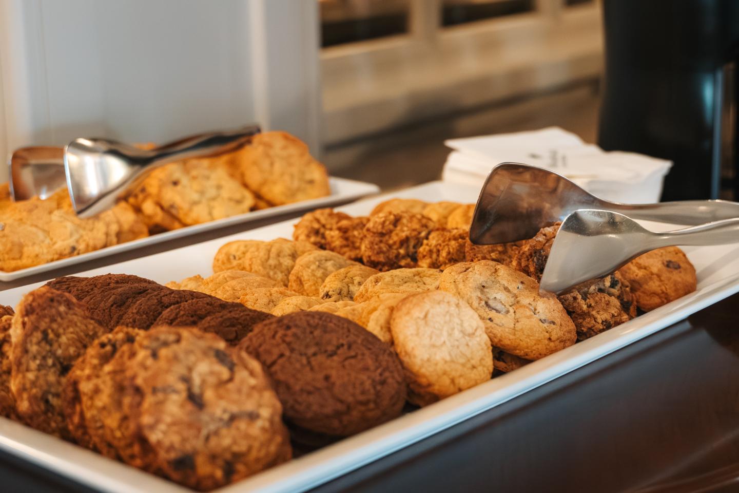 Assorted cookies on trays with tongs nearby for Woodstock Inn & Resort's cookie hour.