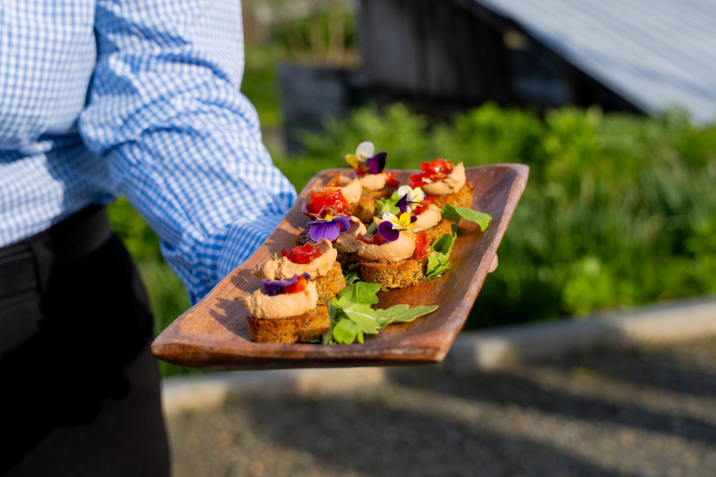 Serving platter with colorful canapés, beautiful outdoor setting of Kelly Way Gardens in Woodstock, Vermont.
