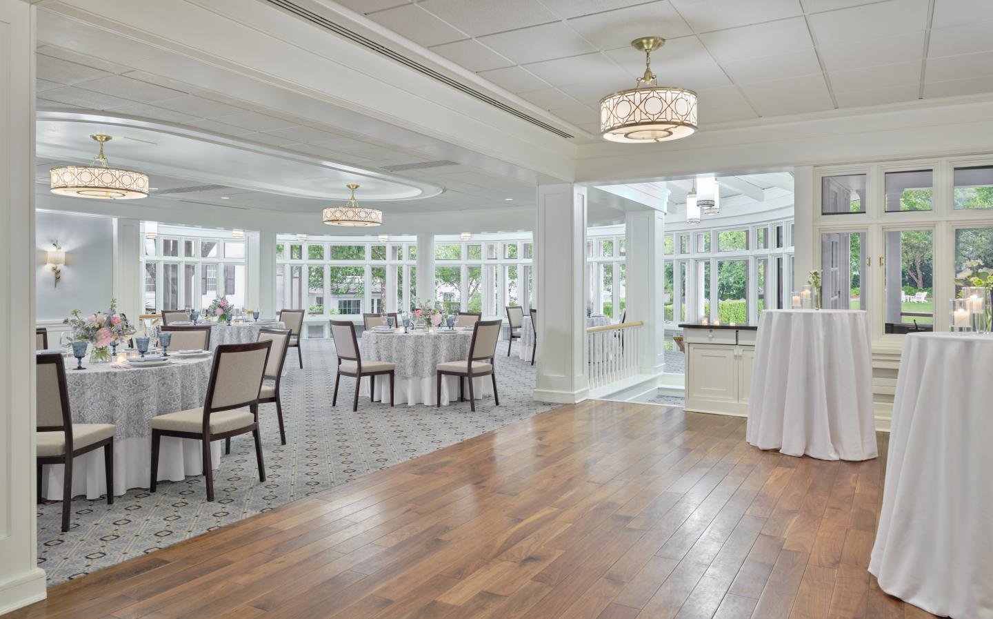 Elegant banquet hall with round tables and large windows.